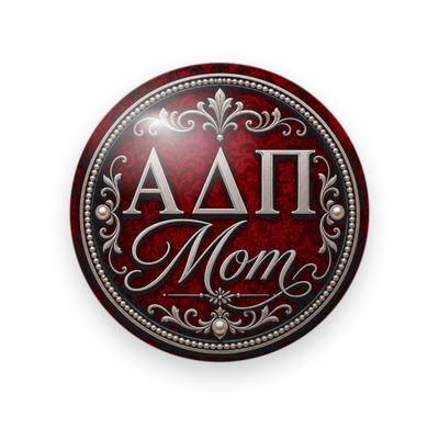 Alpha Delta Pi #056 button. Red damask background with pearl trim and filigree, silver serif Greek letters and silver script “Mom.”