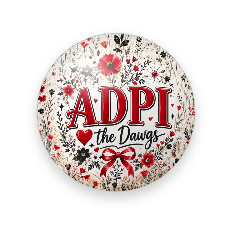Alpha Delta Pi #065 button. Cream background of red and black wildflowers with red serif “ADPI”, a heart, red script “the Dawgs” and a red bow.