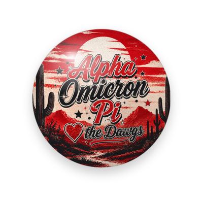 Alpha Omicron Pi #057 button. Red desert sunset with a saguaro cactus and mountains, the full name in red and black script, a heart, “the Dawgs” and stars.