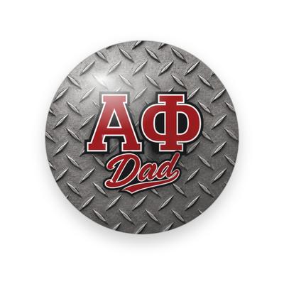 Alpha Phi #064 button. Silver diamond-plate metal background with red block Greek letters outlined in white above red script “Dad.”