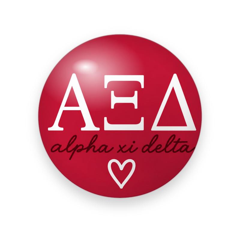 Alpha Xi Delta #034 button. Red background with large white serif Greek letters over the full name in lowercase black script and a white outline heart.