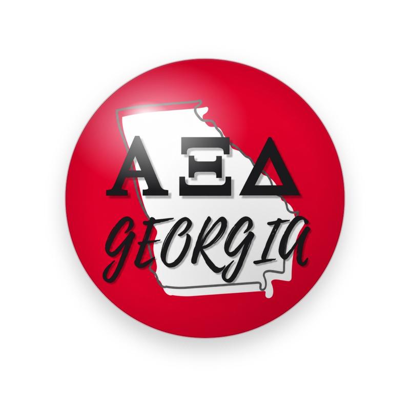 Alpha Xi Delta #047 button. Red background with a white Georgia state outline behind black serif Greek letters and black script “GEORGIA.”