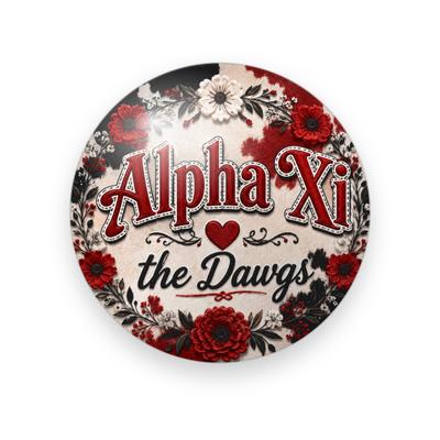 Alpha Xi Delta #051 button. Red and cream cowhide background with red serif “Alpha Xi” lettering outlined in white, a heart, black script “the Dawgs”, and red and cream flowers.