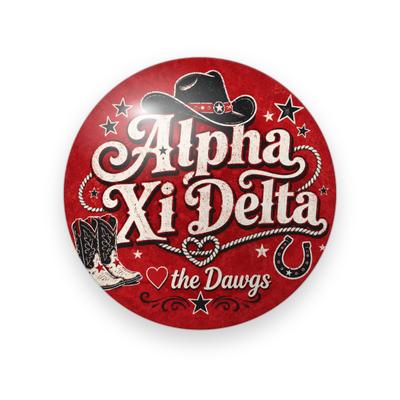 Alpha Xi Delta #056 button. Distressed red background with the full name in cream western lettering, a black cowboy hat, cowboy boots, a horseshoe, a lasso heart, stars, and “the Dawgs.”