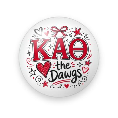 Kappa Alpha Theta #001 button. White background with red Greek letters, a scribbled red heart, black script “the Dawgs”, a red bow, stars, and doodles.