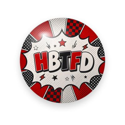 UGA #036 button. Comic-book burst in red, black, and checkerboard panels framing “HBTFD” in red block letters with stars and lightning bolts.