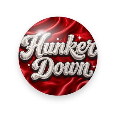 UGA #045 button. Rippled red satin background with “Hunker Down” in puffy white quilted script and small sparkles.