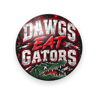 UGA #064 button. Distressed black and red background with “Dawgs Eat Gators” in white and red grunge block letters above a green cartoon gator head.